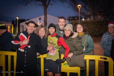 José Antonio Bellido, con ropa deportiva y el dorsal 32, posa junto a un grupo de personas tras su victoria en la San Silvestre de Collado Villalba 2025.
