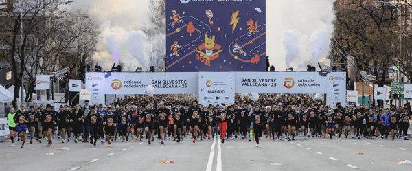Multitud de corredores con camisetas negras tomando la salida en la San Silvestre Vallecana 2025 en Madrid.