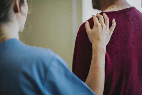 Female nurse touching a patients shoulder
