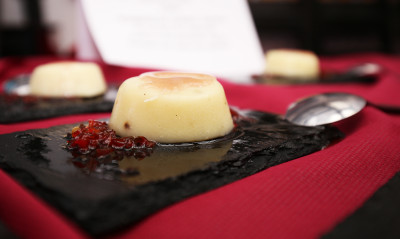 Bombón de queso relleno de anchoa en cama de confitura de pimiento rojo y bañado con salsa de Oporto, de Zona Peñalbar