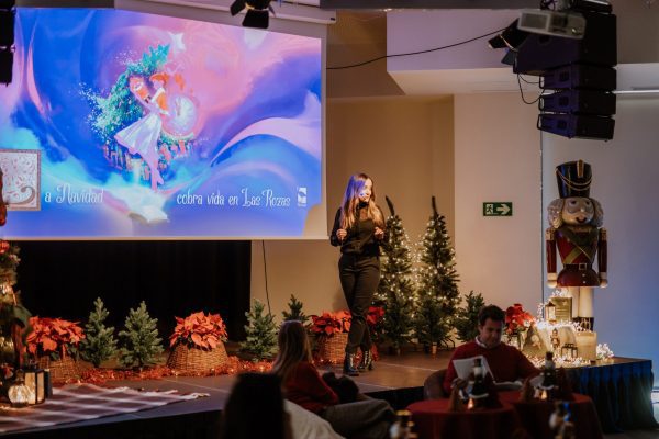 Presentación de la programación de Navidad de Las Rozas en el escenario, con proyecciones y decoración navideña.