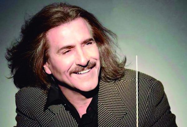 Retrato de cerca del director de orquesta Luis Cobos sonriendo y sosteniendo una batuta.