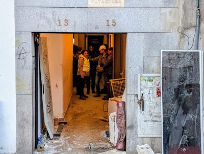 Primer plano del portal del edificio en la calle Real 13-15 de Collado Villalba. En el dintel de piedra se ven los números 13 y 15.