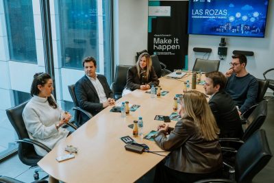 Reunión de trabajo alrededor de una mesa ovalada en una oficina moderna.