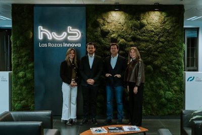 Cuatro personas posando frente a una pared de musgo natural donde destaca un letrero luminoso con la palabra "hub" y el nombre "Las Rozas Innova".