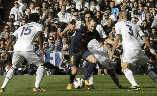Jugador bajo presión defensiva durante un partido de fútbol.