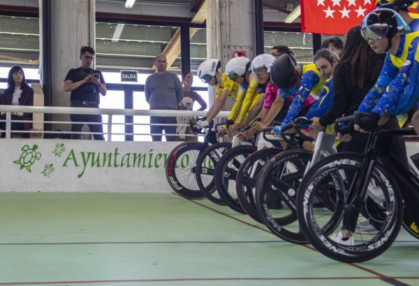 Primer plano lateral de varios ciclistas alineados en la línea de salida del velódromo.