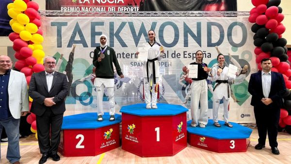 Cuatro taekwondistas en un podio con medallas y diplomas tras el Open de España de Taekwondo en La Nucía.