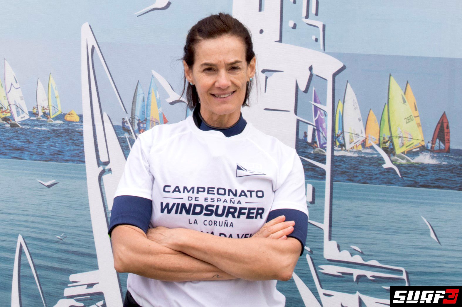 Retrato de Elena Boyé con los brazos cruzados, vistiendo la camiseta oficial del campeonato de windsurf.