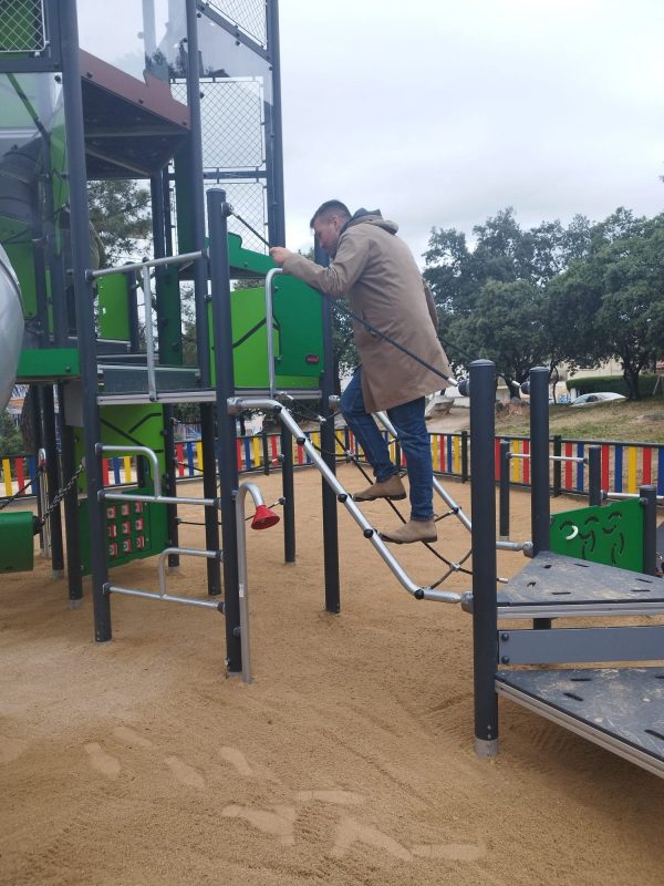 El concejal de Urbanismo, Adan Martínez, subiendo por una red de escalada en la nueva estructura de juegos del parque.