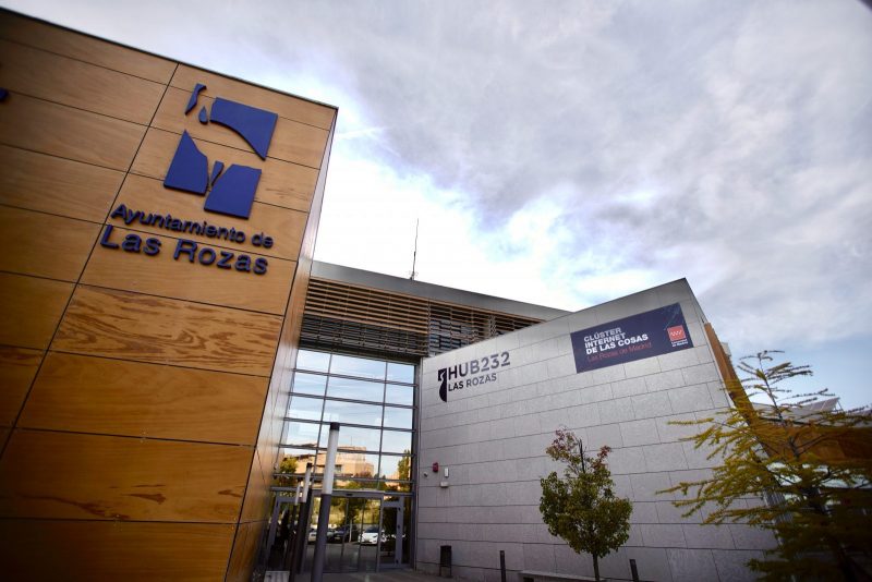 Fachada exterior del edificio HUB232 de Las Rozas, con el logotipo y nombre del Ayuntamiento sobre paneles de madera.