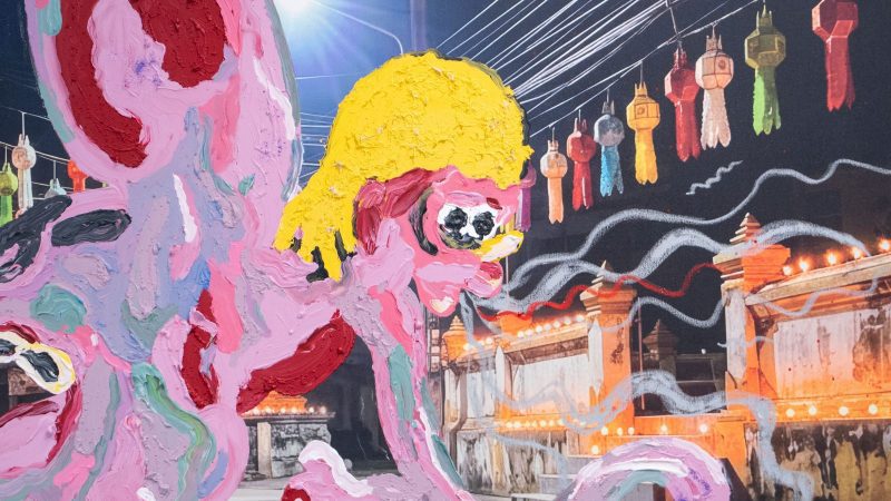 Detalle de un cuadro con trazos gruesos de óleo rosa y amarillo que representa una figura frente a un fondo con farolillos colgados.
