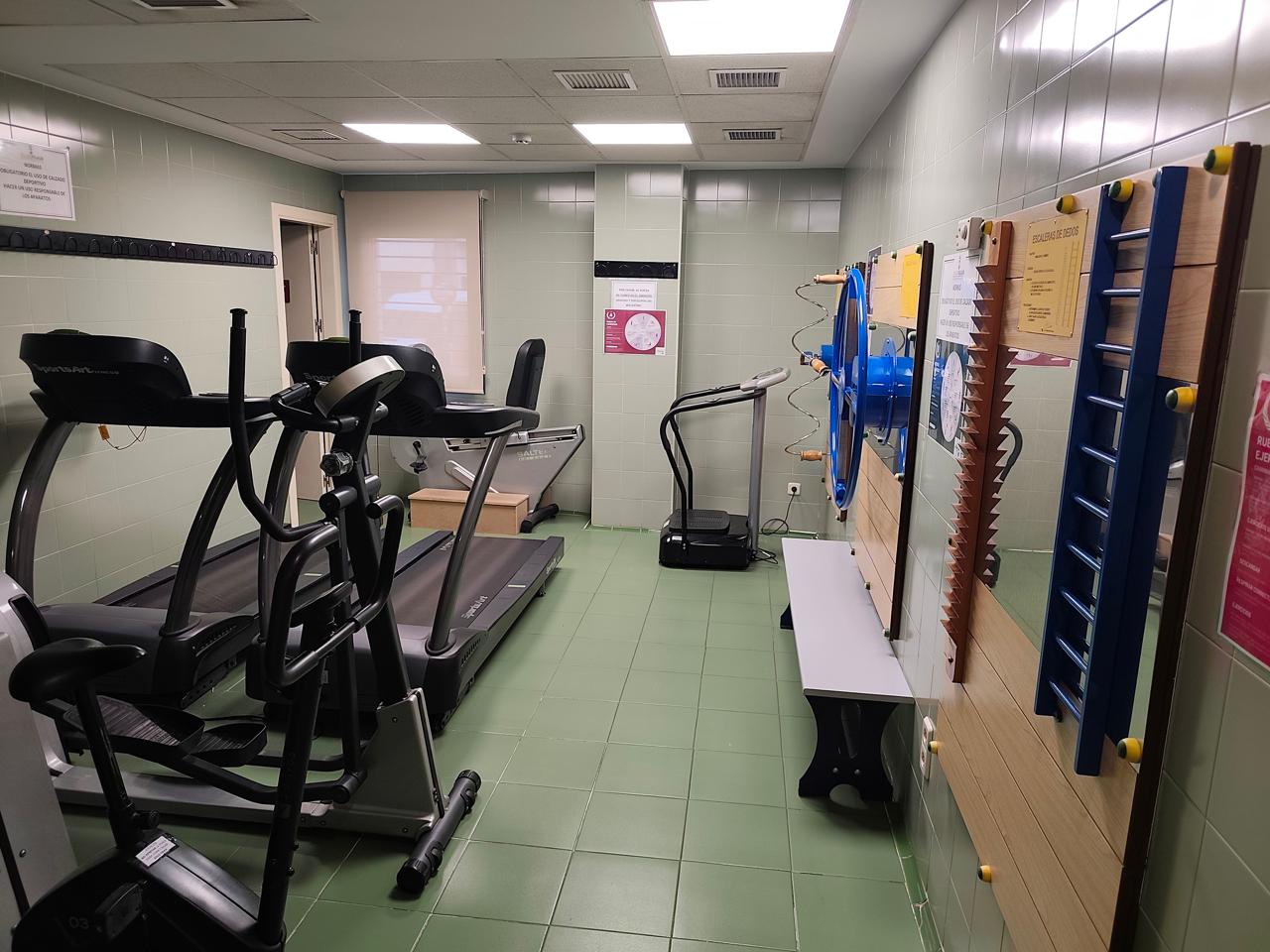 Sala de rehabilitación con cintas de correr, bicicleta elíptica y equipos de fisioterapia en las instalaciones habilitadas.