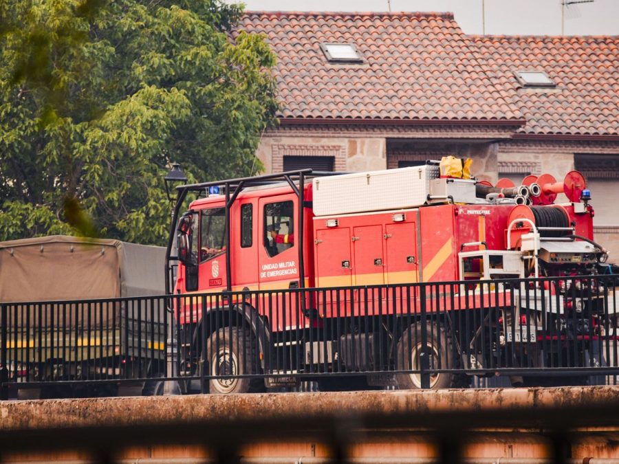 Camión rojo de emergencias de la UME estacionado en una calle frente a casas con tejados de teja.