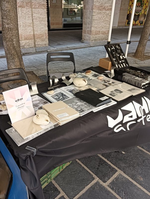 Mesa con cuadernos artesanales y objetos decorativos en un puesto de la Feria Vamm Arte de Collado Villalba