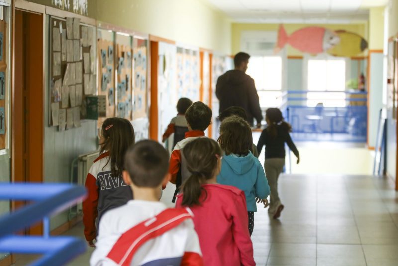 Grupo de alumnos caminando por el pasillo de un colegio al inicio del curso escolar.