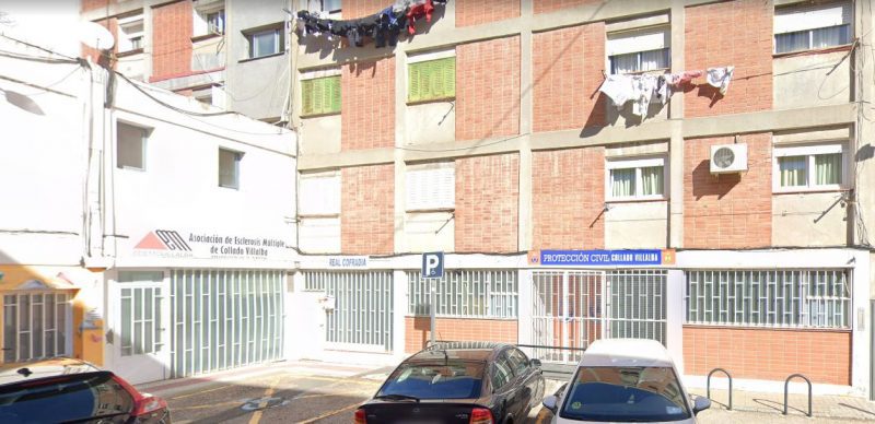 Fachada de edificio residencial de ladrillo visto con el local de Protección Civil en la planta baja.