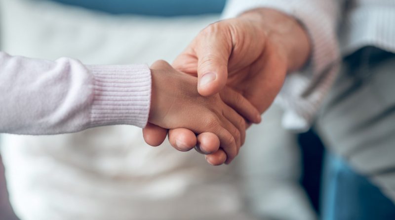 Support. Close up picture of a mans hand holding kids hand