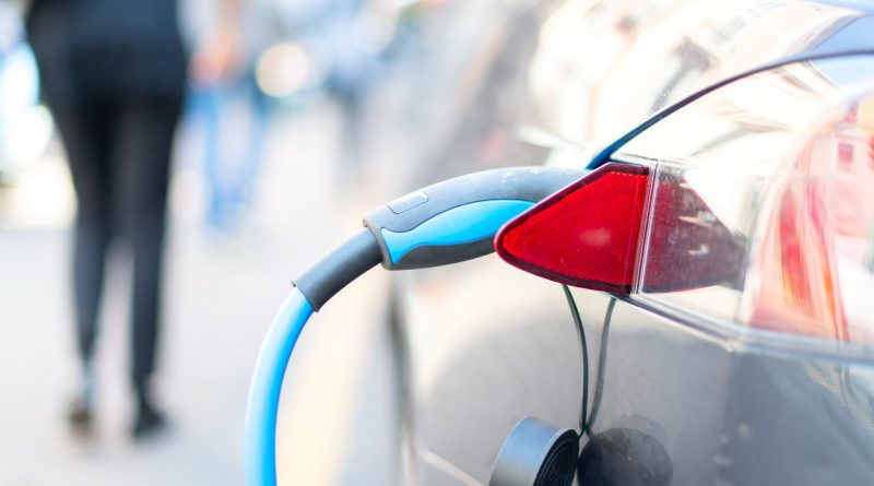 An electric car is charged with energy by a road dispenser