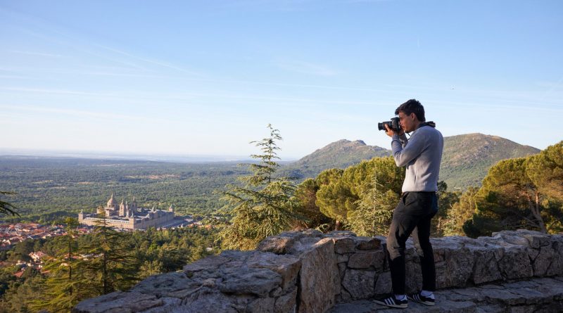 Un turista realiza una fotografía del entorno de San Lorenzo de El Escorial desde uno de los miradores de Abantos