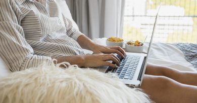 young-woman-sitting-bed-using-laptop-with-healthy-breakfast