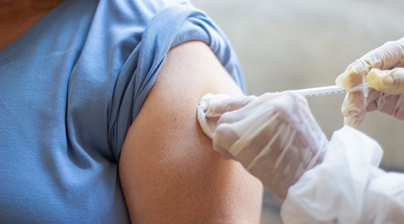 Close-up of nurse hands vaccinating patient with syringe. Doctor injecting patient upper arm. Medicine, vaccination, immunization, healthcare concept
