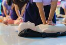 A person performs CPR chest compressions on a during a training session, highlighting essential life-saving techniques and emergency preparedness.